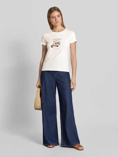Frauenmodel trägt T-Shirt mit Motiv-Print und Rundhalsausschnitt von Zero, Baumwoll-Mix mit Stretch-Anteil, Gerader-Schnitt, Rückenlänge bei Größe 36: 53 cm, cremefarbenes Shirt zu blauer Jeans, Ganzkörperansicht von vorne.