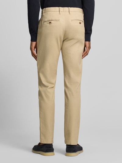 Männermodel trägt Slim Fit Chino aus Baumwoll-Mix von Tommy Hilfiger, unifarben, Logo-Stitching, Materialverarbeitung Piqué, Ganzkörperansicht Rückansicht.