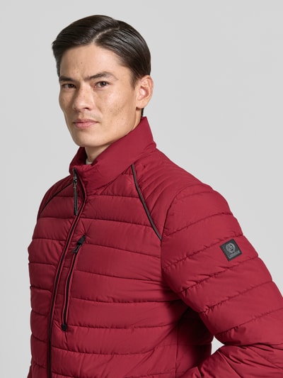 Mannermodel draagt gewatteerd jack met opstaande kraag en ritszakken van LERROS in regular fit, rood, Nahaufnahme Oberkörper. Ruglengte maat M: 69 cm, schouderbreedte: 46 cm, borstwijdte: 60 cm, mouwlengte: 69 cm.