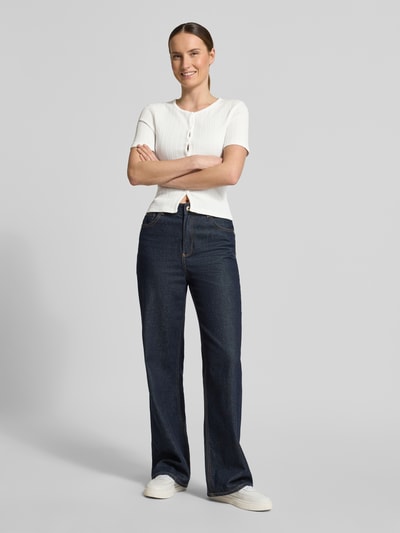Frauenmodel trägt Strickshirt mit Knopfleiste Modell 'SAJUNI' von Samsøe Samsøe aus Reine Baumwolle im Regular-Fit, Weiß mit Motiv-Print, Rundhalsausschnitt, kombiniert mit dunkler Jeans, Ganzkörperansicht von vorne.