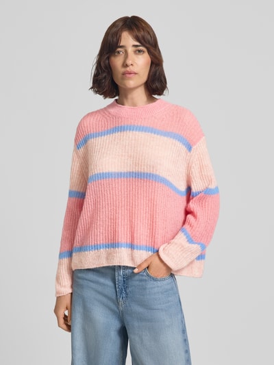 Frauenmodel trägt Strickpullover aus Alpaka-Mix mit Rundhalsausschnitt von Closed, rosa und blau gestreift, relaxed Fit, Ganzkörperansicht von vorne.