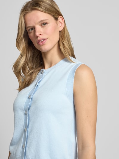 Frauenmodel trägt Regular Fit Pullunder aus Viskose-Mix Modell 'ORINA' von Pieces in Hellblau, Feinstrick, Zierknöpfe, Nahaufnahme Oberkörper.