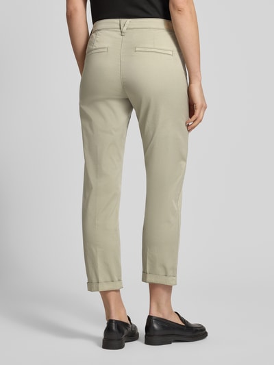 Frauenmodel trägt Chino mit Eingrifftaschen von MAC aus Baumwoll-Elasthan-Mix in Beige, Regular-Fit, Gesäßtaschen, Ganzkörperansicht Rückansicht.