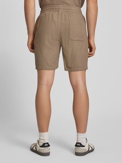 Männermodel trägt Regular Fit Shorts aus Viskose-Leinen-Mix Modell 'TEL LATHAM' von Only & Sons in Beige mit Struktur, Ganzkörperansicht Rückansicht