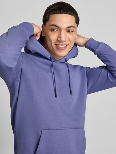Männermodel trägt Regular Fit Hoodie aus Baumwoll-Mix Modell 'CERES' von Only & Sons in Optik: Unifarben mit Label-Stitching-Applikation, Kängurutasche und Kapuze mit Tunnelzug, Materialverarbeitung: Sweat, Nahaufnahme Oberkörper.