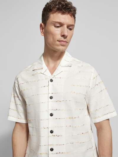 Männermodel trägt Regular Fit Freizeithemd mit Knopfleiste Modell 'klampo' von Matinique aus cremefarbenem Baumwoll-Mix, Nahaufnahme Oberkörper. Rückendetails und Schnittmaße laut Kontext: Kentkragen, Rückenlänge 77 cm, Schulterbreite 44 cm, Ärmellänge 29 cm, Viskose-Anteil.
