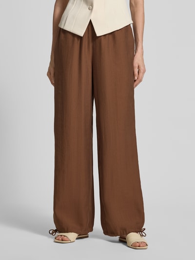 Frauenmodel trägt Wide Leg Pants mit elastischem Bund und Kordelzug von Rich & Royal aus Lyocell-Mix im Loose-Fit, braun, Nahaufnahme Unterkörper.