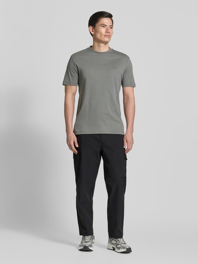 Männermodel trägt Relaxed Fit Cargohose mit Gürtelschlaufen Modell 'SRACKY' von BOSS Orange, Optik: Unifarben, Ganzkörperansicht von vorne.