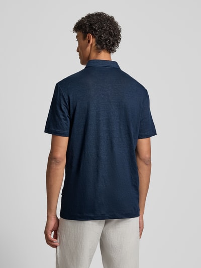 Männermodel trägt Slim Fit Poloshirt aus Leinen-Elasthan-Mix von OLYMP Level Five in Dunkelblau, strukturierte Oberfläche, Ganzkörperansicht Rückansicht.