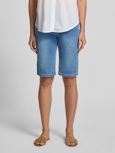 Frauenmodel trägt Jeansshorts mit asymmetrischem Knopfverschluss Modell 'Malibu' von Buena Vista aus Baumwoll-Mix mit Stretch-Anteil, Straight Fit, 5-Pocket-Design, Bundweite bei Größe S: 36 cm, Innenbeinlänge bei Größe S: 33 cm, hellblau, glatte Struktur, Ganzkörperansicht von vorne.