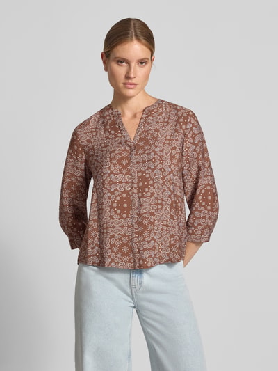 Frauenmodel trägt Relaxed Fit Kurzarmbluse aus Viskose-Mix von s.Oliver RED LABEL in Braun mit weißem Paisley-Muster, Ganzkörperansicht von vorne.
