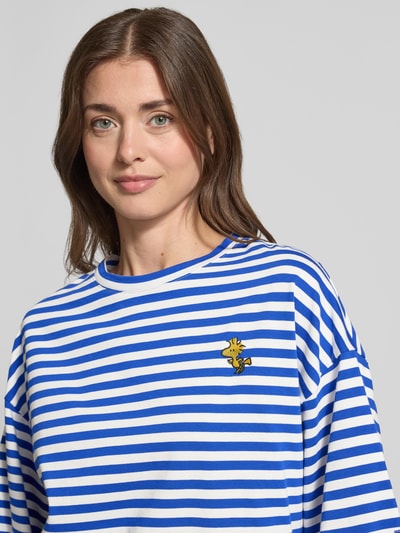 Kobiece modelka nosi damski t-shirt Oversized T-Shirt aus reiner Baumwolle Modell 'JARINERO STRIPED' od Essentiel Antwerp, efekt: wzór w paski na całej powierzchni, okrągły dekolt, rękaw o dł. 1/2, wyhaftowany motyw, dżersej z czystej bawełny, kolor niebiesko-biały, zbliżenie na górną część ciała.