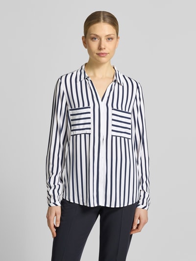 Vrouwenmodel draagt Bluse aus Viskose mit Brusttaschen van Christian Berg Woman in zuiver viscose met recht model, overhemdkraag, knoopsluiting, borstzakken, ruglengte maat 36: 71 cm, mouwlengte maat 36: 65 cm, wit met donkerblauwe verticale strepen, gladde textuur. Ganzkörperansicht van voren.