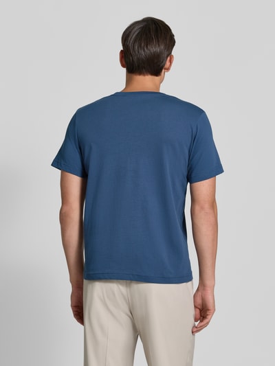 Männermodel trägt Regular Fit T-Shirt aus reiner Baumwolle von Tom Tailor in Blau, kombiniert mit heller Hose, Ganzkörperansicht Rückansicht. Herren T-Shirt von Tom Tailor.