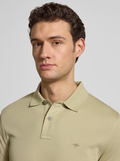 Männermodel trägt Regular Fit Poloshirt mit Logo-Stitching von Fynch-Hatton in Beige, reine Baumwolle, Nahaufnahme Oberkörper.