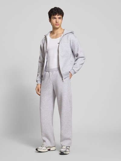 Männermodel trägt Sweatpants mit elastischem Bund von REVIEW, Material-Mix mit Baumwoll-Anteil, Relaxed-Fit, Gesäßtasche, Ganzkörperansicht von vorne.