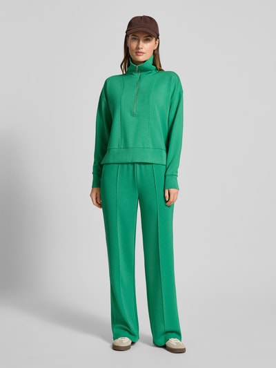 Vrouwenmodel draagt groen Sweatshirt met Umlegekragen van Christian Berg Woman, los vallend, geribde boorden, voorkant volledige lichaamsweergave.