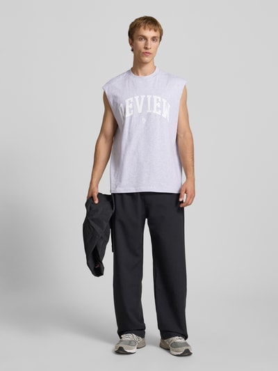 Männermodel trägt Tanktop mit Logo-Print von REVIEW aus Reine Baumwolle, Gerader-Schnitt, Rundhalsausschnitt, Rückenlänge 68 cm, Ganzkörperansicht von vorne