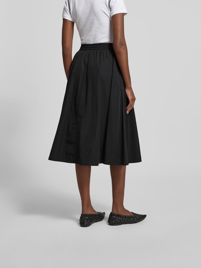 Frauenmodel trägt Midirock mit Baumwoll-Anteil von Kenzo in Schwarz, A-Linie, Midilänge, elastischer Bund mit Tunnelzug, Label-Detail, Ganzkörperansicht Rückansicht.