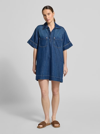 Frauenmodel trägt Regular-Fit Jeanskleid aus Baumwoll-Mix mit Lyocell-Anteil von BOSS Orange, Denim-Optik, Mini-Länge, Johnny-Kragen, Kurzarm, Brusttasche, Rückenpasse mit Kellerfalte, Twill Materialverarbeitung, Ganzkörperansicht von vorne.