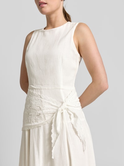 Frauenmodel trägt Midikleid aus Viskose-Mix mit Spitzenbesatz von Mango, cremeweiß, taillierte Passform, Rundhalsausschnitt, Ärmelloses-Design, Ganzkörperansicht von vorne, Rückenlänge bei Größe S: 126 cm, Brustweite bei Größe S: 44 cm, Leinen-Anteil.