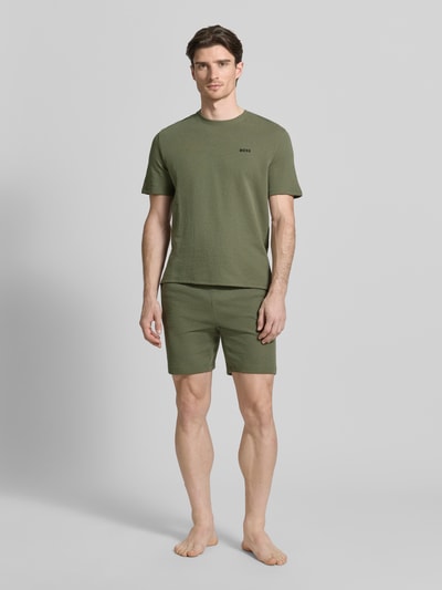 Männermodel trägt Regular Fit Pyjama-Oberteil aus Baumwoll-Mix Modell 'WAFFLE' von BOSS in Optik: Unifarben, Piqué, Label-Stitching-Applikation, Rundhals, Kurzarm, Ganzkörperansicht von vorne.