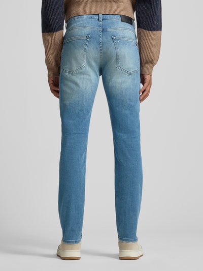 Männermodel trägt Slim Fit Jeans aus Baumwoll-Mix Modell 'DELAWARE' von BOSS Orange, Denim-Optik, Label Patch, Ganzkörperansicht Rückansicht.