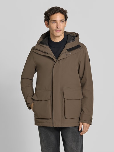Männermodel trägt Regular Fit Jacke mit aufgesetzten Taschen Modell 'Liam' von Didriksons in Braun mit Kapuze, Ganzkörperansicht von vorne. Rückenlänge 79 cm, Schulterbreite 44 cm, Brustweite 45 cm, Ärmellänge 70 cm.