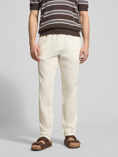 Mężczyzna nosi Straight Fit Leinenhose mit elastischem Bund Modell 'Barton' von Matinique, mieszanka lnu i bawełny, szerokość w rozmiarze M: 34 cm, długość wewnętrzna nogawki: 78 cm, spodnie z prostymi nogawkami, elastyczny pas z tunel, kieszenie z tyłu, kolor jasny krem, tekstura gładka. Ganzkörperansicht von vorne.