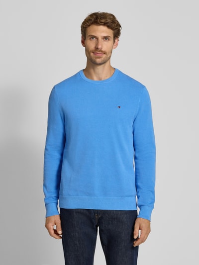 Męski model nosi Regular Fit Pullover aus reiner Baumwolle od Tommy Hilfiger, jasnoniebieski kolor, tekstura gładka, Ganzkörperansicht von vorne.