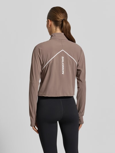 Frauenmodel trägt Cropped Pullover für intensive Anstrengungen und Beschleunigung von Salomon, Material-Mix mit Stretch-Anteil, Logo, Stehkragen, Reißverschluss, Rückenlänge bei Größe S 47 cm, Ganzkörperansicht Rückansicht