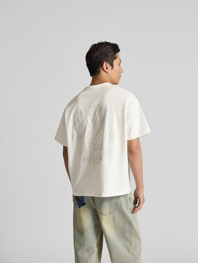 Männermodel trägt Regular Fit T-Shirt aus Baumwoll-Mix von Don´t Waste Culture, helles Unifarbenes-Design mit Label-Detail, Rückenlänge 68 cm, Ganzkörperansicht Rückansicht.