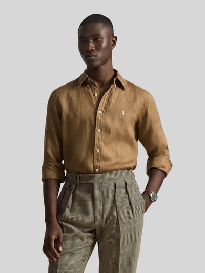 Mannenmodel draagt Regular Fit Freizeithemd aus reinem Leinen van Polo Ralph Lauren in effen lichtbruin, linnenstructuur, knoopsluiting, logo detail, button-down kraag, lange mouwen met sportmanchet, licht afgeronde zoom, flammengaren, Custom Fit, Ganzkörperansicht von vorne.