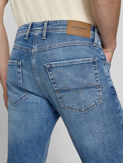Mężczyzna nosi Straight Fit Jeans aus Baumwoll-Mix Modell 'ARNE' od MAC, jasnoniebieski denim z brązową naszywką, detailaufnahme, Herren Straight Fit Jeans von MAC
