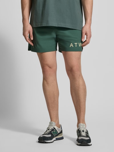 Männermodel trägt Shorts mit elastischem Bund von HALO in Grün mit Label-Print, Material-Mix mit Stretch-Anteil, Regular-Fit, Nahaufnahme Unterkörper.