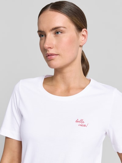 Frauenmodel trägt T-Shirt mit Statement-Stitching und Rundhalsausschnitt von Christian Berg Woman aus reiner Baumwolle, Nahaufnahme Oberkörper.