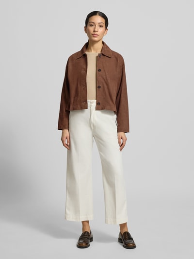 Kobiece model prezentuje Regular Fit Jacke aus echtem Lammvelours mit Umlegekragen od Windsor, brąz i beż, krój regular fit, kieszenie boczne, zapięcie na guziki, całościowy widok z przodu.