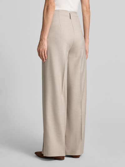 Frauenmodel trägt Wide Fit Hose mit Viskose-Anteil von MORE & MORE in Beige mit Bundfalten, strukturierte Oberfläche, Ganzkörperansicht Rückansicht.
