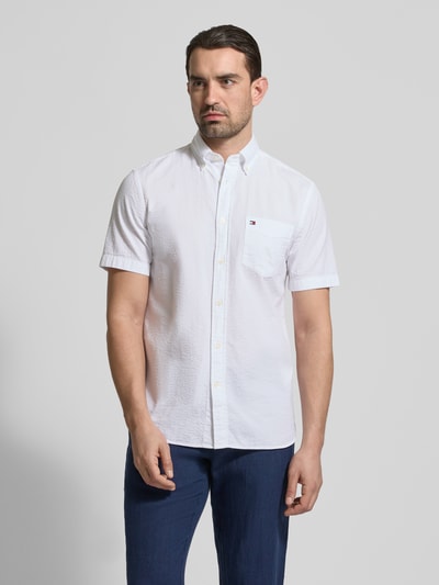 Männermodel trägt Regular Fit Freizeithemd aus reiner Baumwolle von Tommy Hilfiger, Optik: Unifarben, Crinkle, Logo-Stitching, Ganzkörperansicht von vorne.