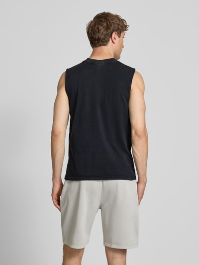 Männermodel trägt Tanktop mit Label-Stitching und Rundhalsausschnitt von Pegador aus Reine Baumwolle im Relaxed-Fit, Rückenlänge 66 cm, Ganzkörperansicht Rückansicht.