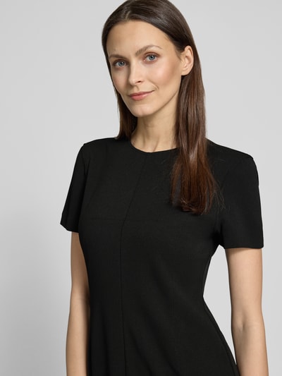Modelka kobieca ma na sobie Knielanges Etuikleid mit Rundhalsausschnitt od Calvin Klein Womenswear, materiał z domieszką stretchu, krój prosty, kolor czarny, długość do kolan, okrągły dekolt, długość pleców w rozmiarze S: 92 cm, szerokość w rozmiarze S: 43 cm, długość rękawa w rozmiarze S: 19 cm, zbliżenie na górną część sylwetki