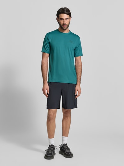 Männermodel trägt Regular Fit T-Shirt mit Logo-Print Modell 'Vanish' von Under Armour in Türkis, elastischer Material-Mix, Ganzkörperansicht von vorne.