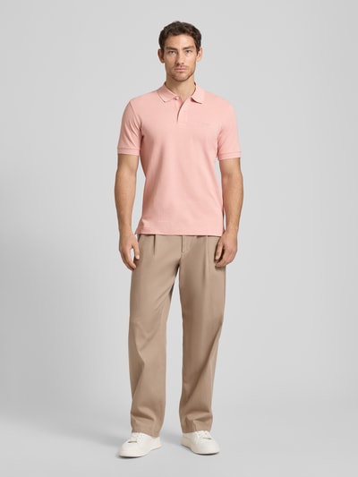 Männermodel trägt Regular Fit Poloshirt aus reiner Baumwolle Modell 'PALLAS' von BOSS, Optik: Unifarben, Ganzkörperansicht von vorne.