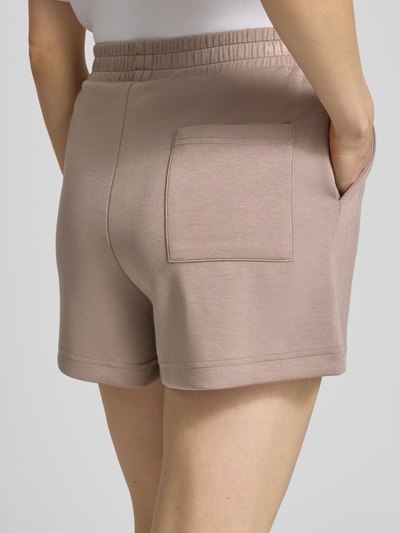 Frauenmodel trägt Relaxed Fit Shorts mit Modal-Anteil von Marc O'Polo, Optik: Unifarben, Materialverarbeitung: Sweat, Gesäßtasche, Ganzkörperansicht Rückansicht.