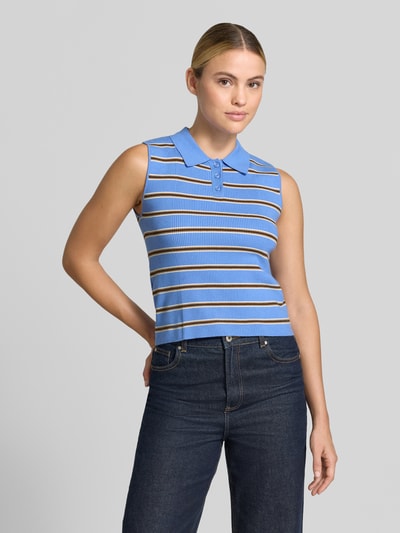 Frauenmodel trägt Regular Fit Poloshirt aus Viskose-Mix von MANGO in Blau mit Strukturmuster und Streifen, ärmellos, Nahaufnahme Oberkörper. Rückenlänge bei Größe S: 47 cm.