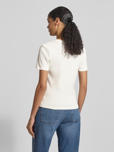 Frauenmodel trägt Slim Fit T-Shirt aus reiner Baumwolle von Tommy Hilfiger in Unifarbe, kurzarm, Jersey, Logo-Stitching, Ganzkörperansicht Rückansicht.