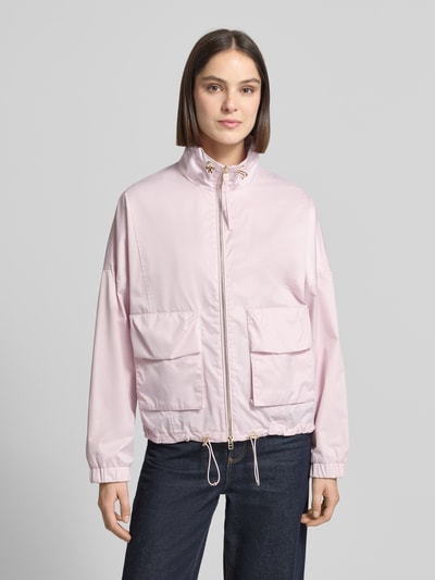 Vrouwenmodel draagt Jacke met verstelbare zoom model 'Oriella' van JOOP!, recht model, opstaande kraag, tweewegritssluiting, opgestikte klepzakken, elastische mouwboorden, verstelbare zoom met koordstopper, ruglengte maat 36: 61 cm, schouderbreedte: 38 cm, borstwijdte: 62 cm, mouwlengte: 64 cm, lichtroze tint, gladde textuur, vooraanzicht van het hele lichaam.