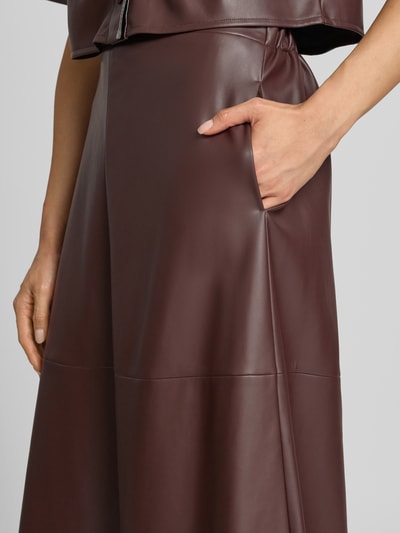 Vrouwenmodel draagt midirok in leerlook van Vera Mont, dames midirok in A-lijn met onderrok en deels elastische band, detailopname