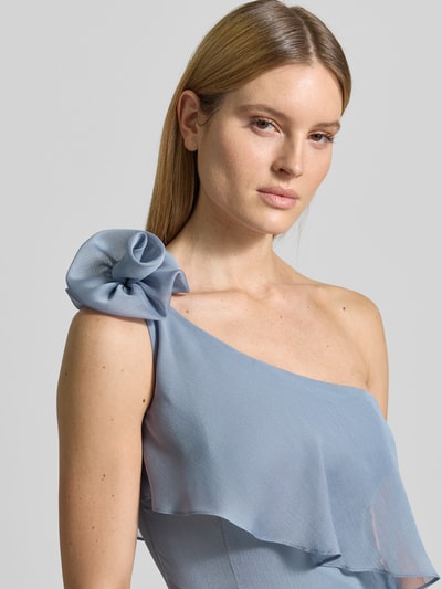Frauenmodel trägt Regular Fit Jumpsuit mit floralem Zierbesatz von Swing in zartem Hellblau mit Rüschenbesatz, Nahaufnahme Oberkörper. Kontext: Damen Jumpsuit, Regular-Fit, taillierte Passform, ärmelloses Design, asymmetrisch, Rückenlänge 40 cm, Brustweite 42 cm, Gesamtlänge 150 cm, Innenbeinlänge 80 cm.