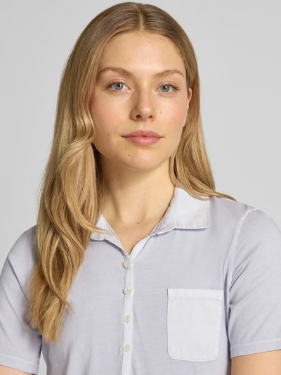 Frauenmodel trägt Regular Fit Poloshirt aus reiner Baumwolle von Marc O'Polo, Optik: Unifarben, Logo-Print, Polokragen, kurze Knopfleiste, Kurzarm, Brusttasche, Materialverarbeitung: Jersey, Nahaufnahme Oberkörper